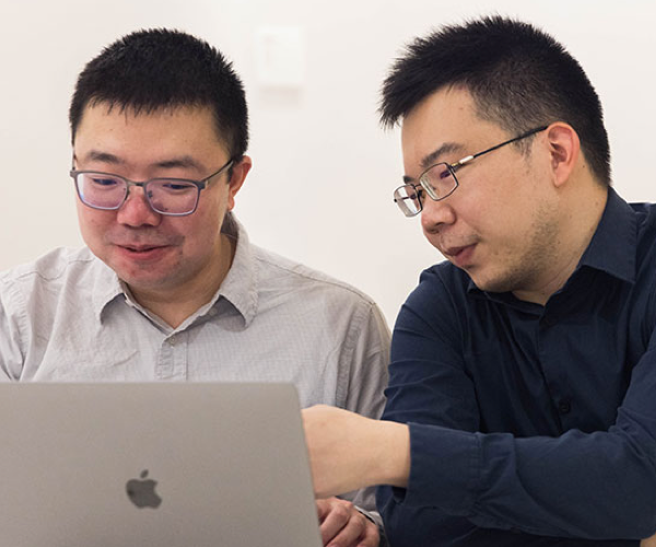 Two students looking at a computer together.
