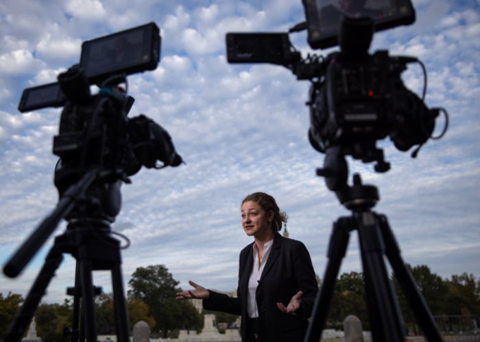 A person speaking in front of cameras