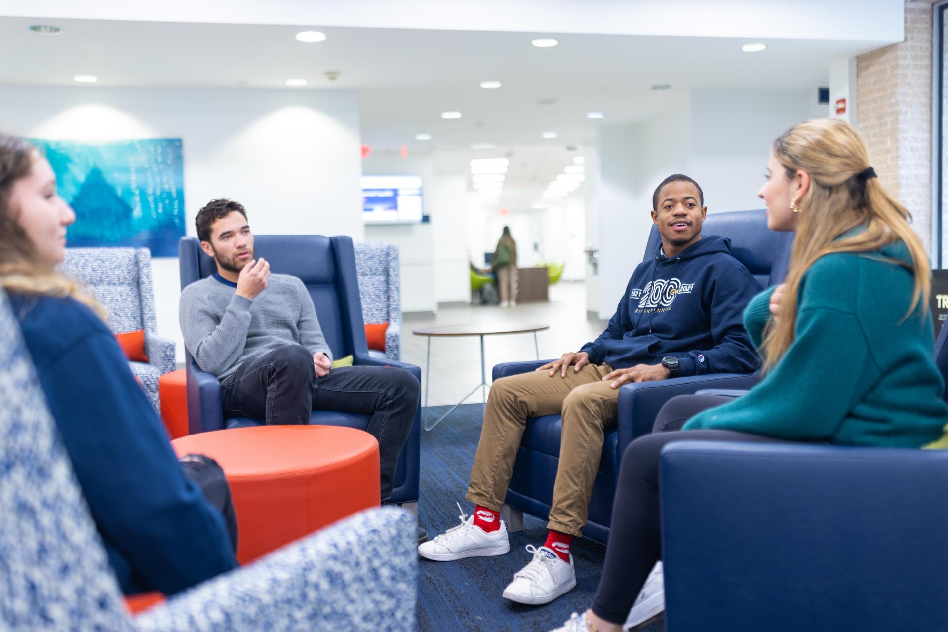 Four students sit talking in the University Student Center